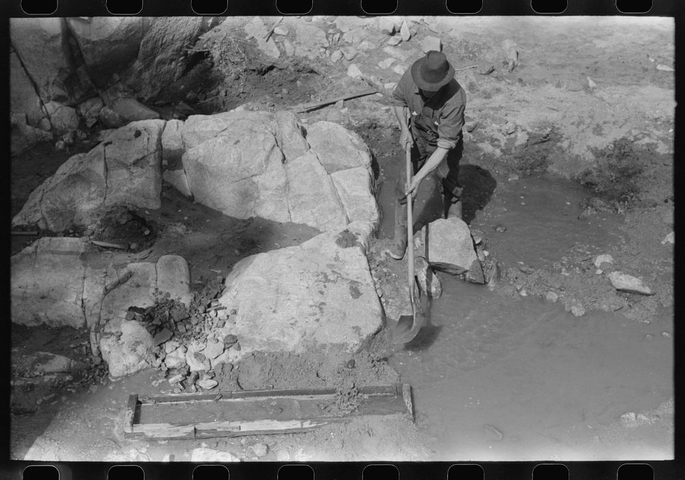 Prospector working the sluice box. Pinos Altos, New Mexico by Russell Lee