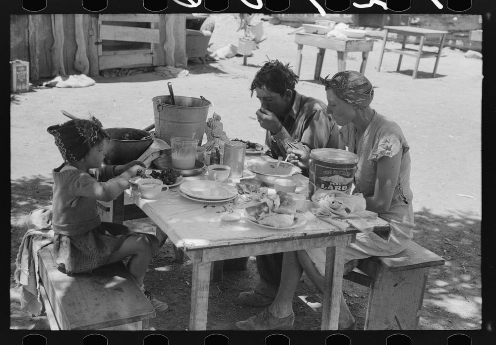 The Caudill family eating dinner in the open the day thew were moving their dugout. Pie Town, New Mexico by Russell Lee