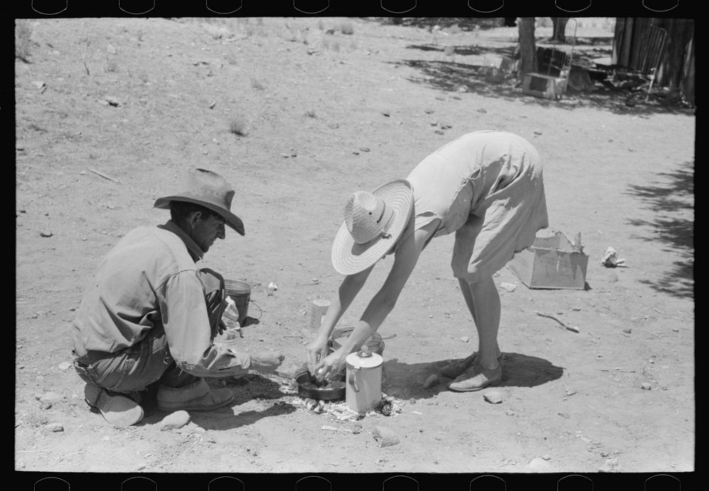 Faro and Doris Caudill cooking dinner over camp fire, Pie Town, New Mexico by Russell Lee