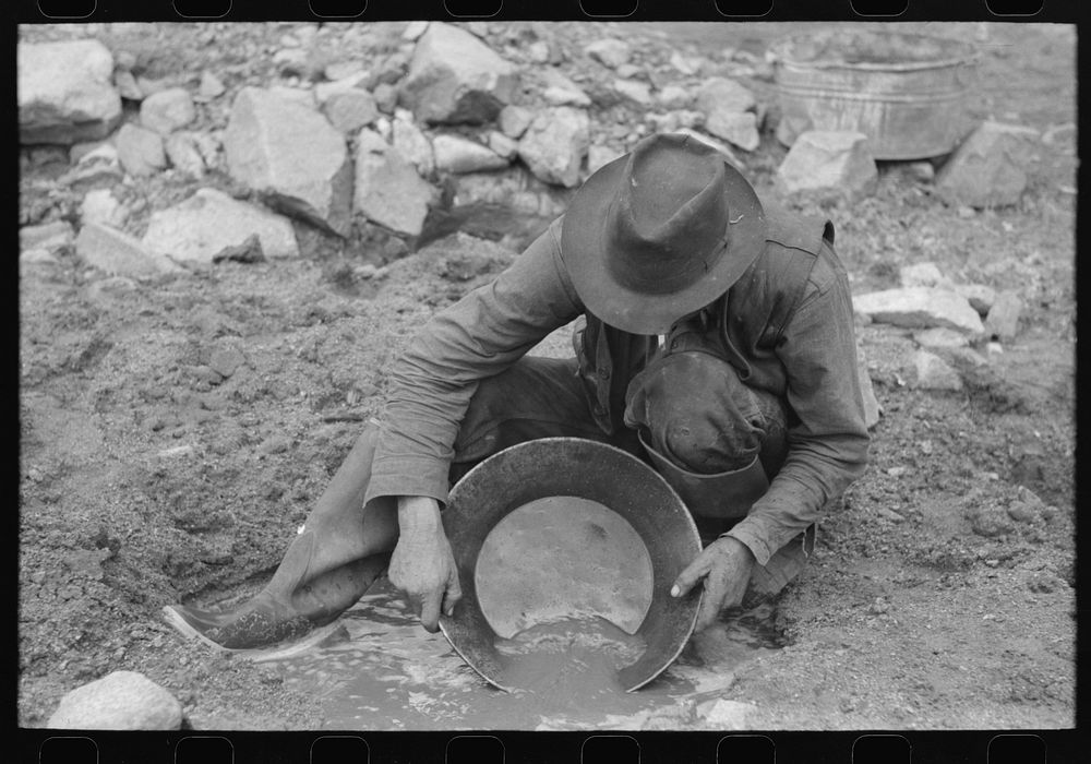 Prospector washing a "pan" of gold-bearing dirt. Pinos Altos, New Mexico by Russell Lee