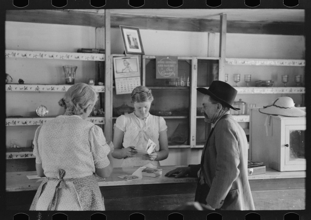 Louis Stagg who runs the cafe and her mother looking at greeting cards which the salesman has. Pie Town, New Mexico by…