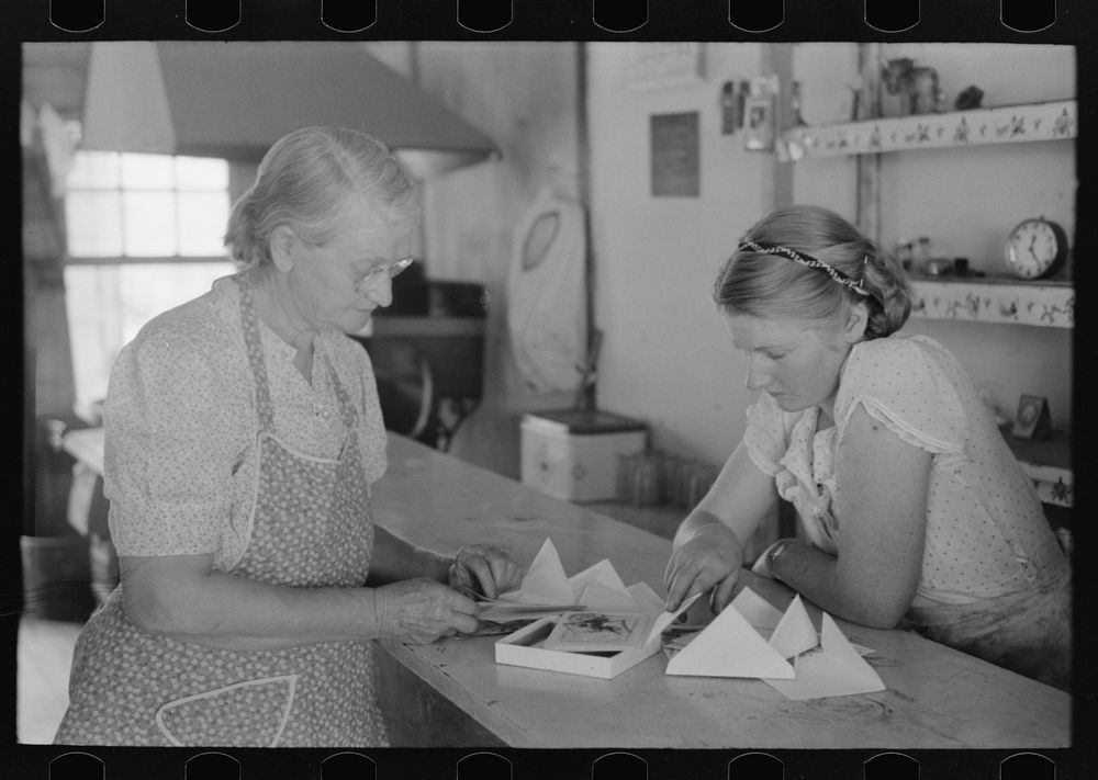Louis Stagg who runs the cafe and her mother looking at greeting cards. Pie Town, New Mexico by Russell Lee