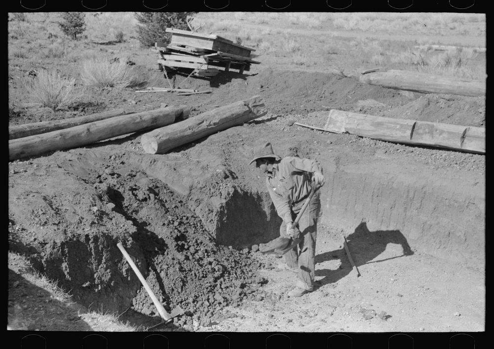 Faro Caudill shoveling out dirt while building steps of his dugout, Pie Town, New Mexico by Russell Lee