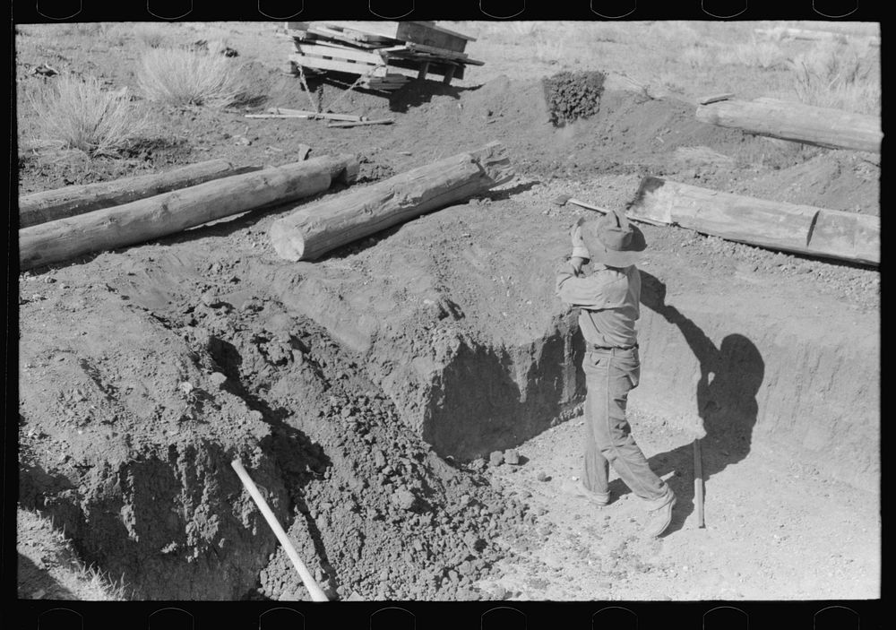 [Untitled photo, possibly related to: Faro Caudill shoveling out dirt while building steps of his dugout, Pie Town, New…