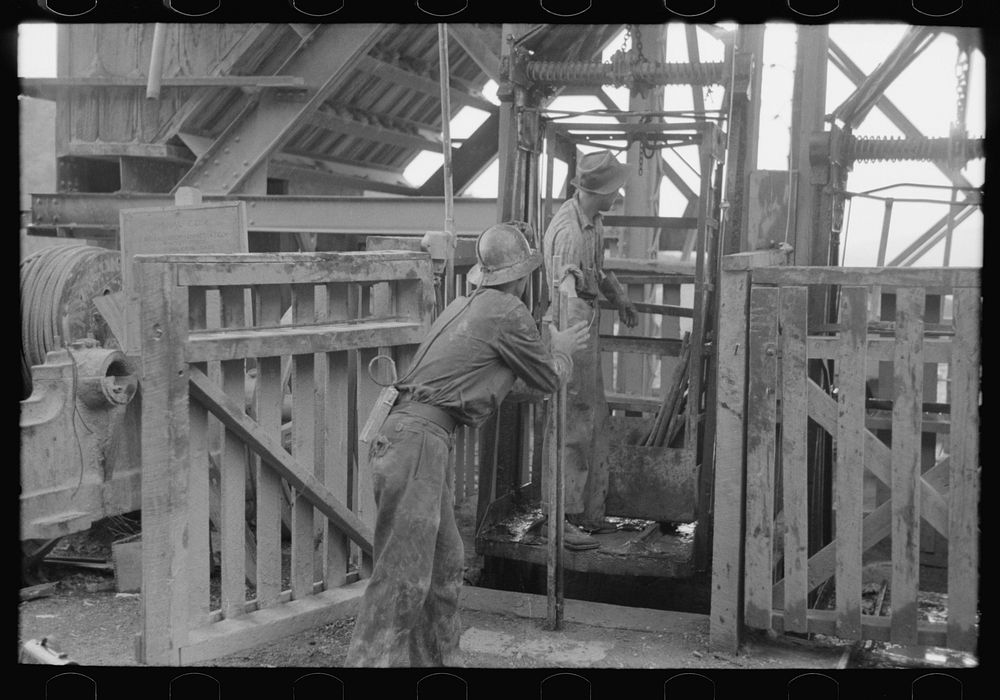 Miners loading drilling equipment onto hoist to take. Mogollon, New Mexico by Russell Lee