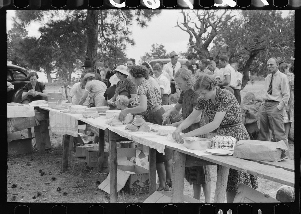 Putting food on the tables for dinner at the all day community sing. Pie Town, New Mexico by Russell Lee