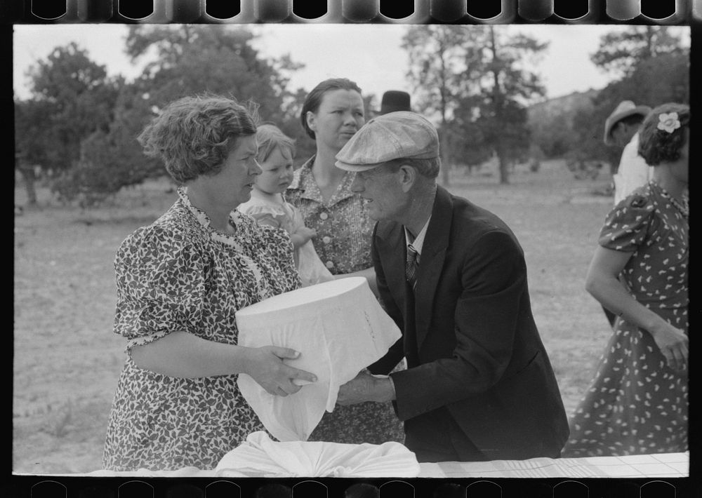 Mrs. Stagg handing pan of food to Mr. Stagg to put on the table at dinner of all day community sing. Pie Town, New Mexico by…