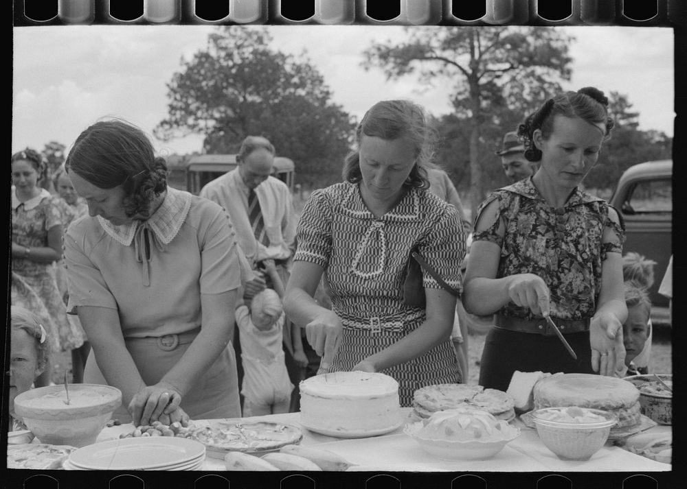Cutting cakes, dinner of all day community sing. Pie Town, New Mexico by Russell Lee