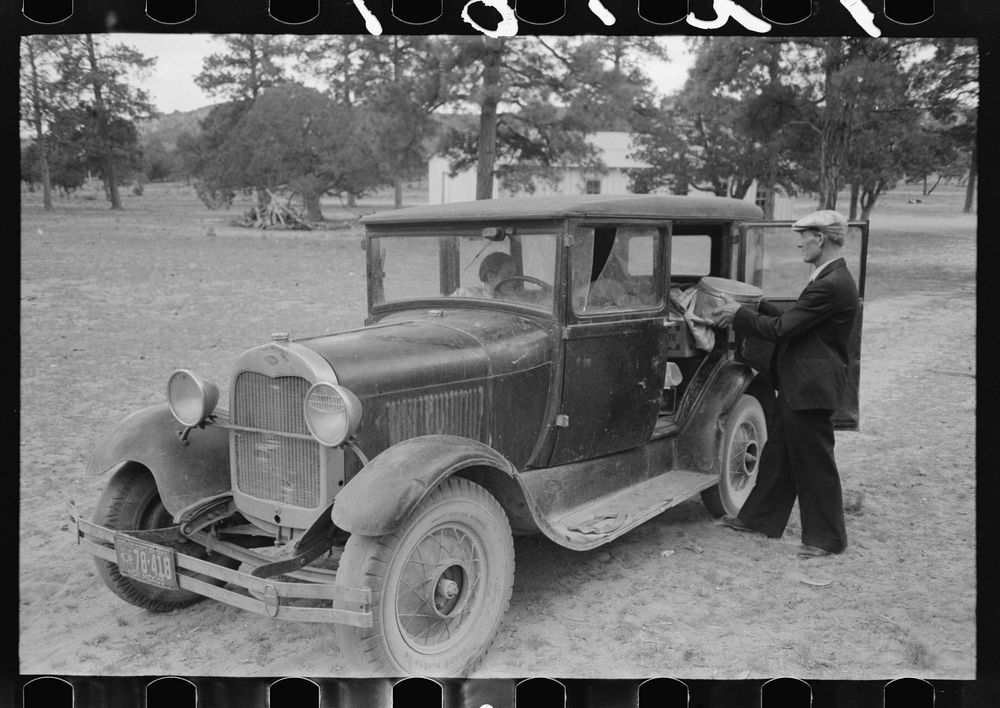 Mr. Bill Stagg putting container of food which was left from dinner at the community sing back into the car. Pie Town, New…