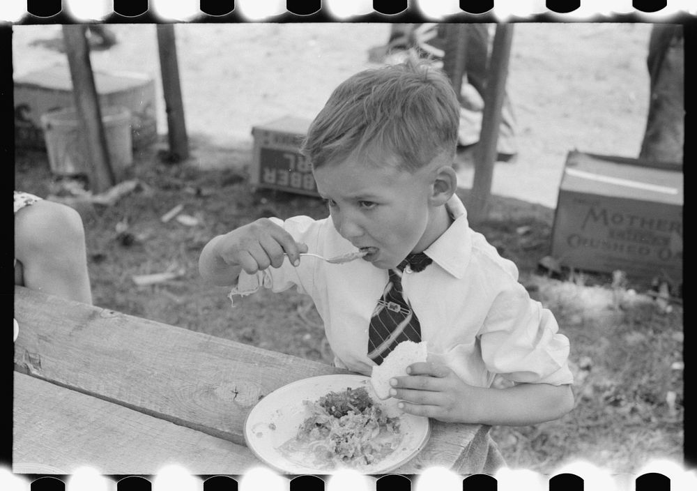 Youngster eating dinner at all day community sing, Pie Town, New Mexico by Russell Lee