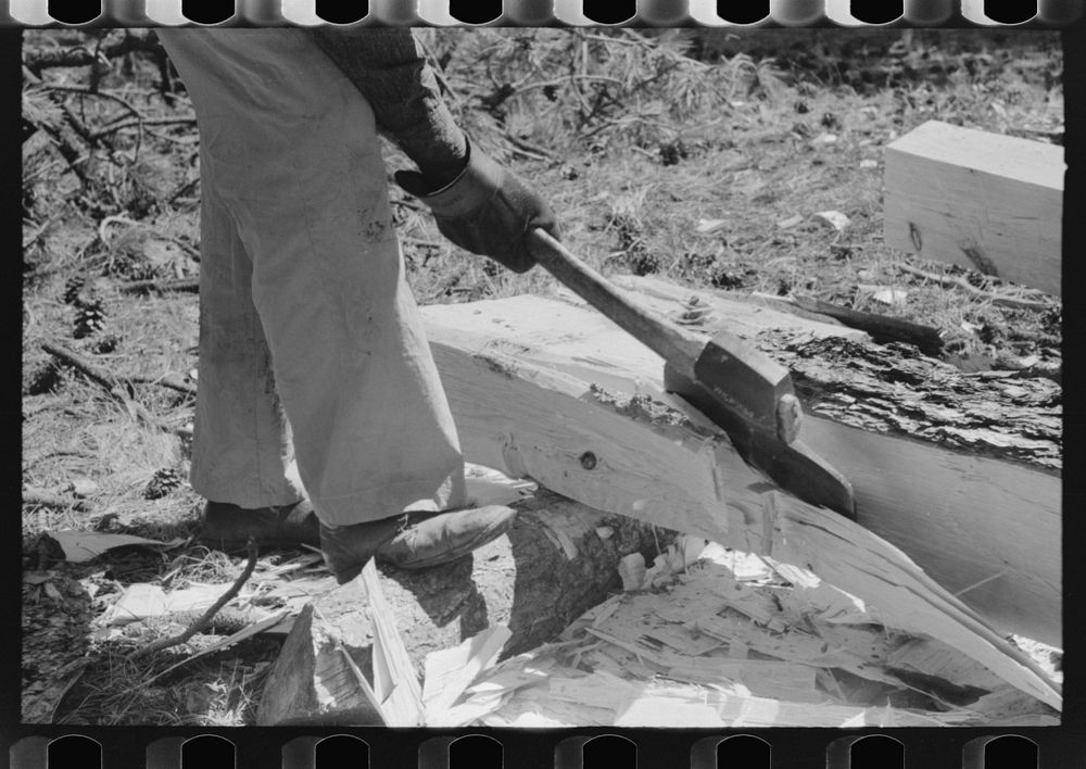 Using a broad axe to remove large chunks from log which will be made into a tie, Pie Town, New Mexico by Russell Lee