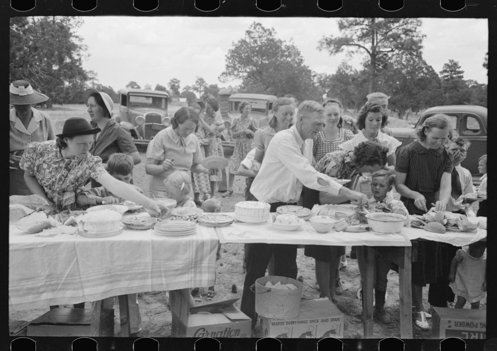 Farm folks, mostly homesteaders, at dinner during the all day community sing, Pie Town, New Mexico by Russell Lee