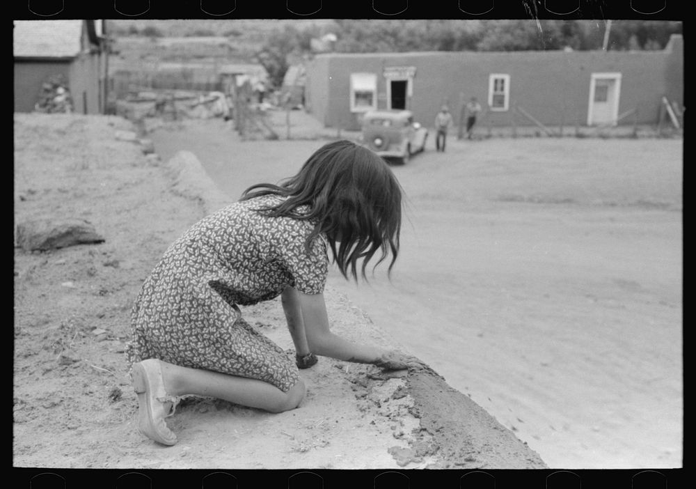[Untitled photo, possibly related to: Spanish-American girl plastering edge of roof of adobe house. Costilla, New Mexico] by…