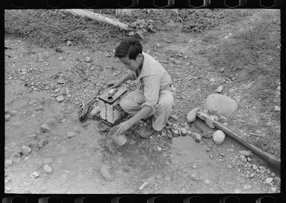 [Untitled photo, possibly related to: A Spanish-American boy dipping water from irrigating ditch. Water will be used in…