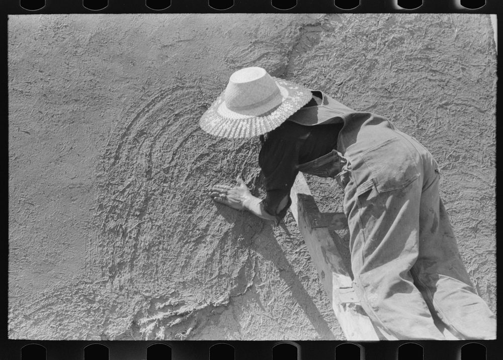 [Untitled photo, possibly related to: Spanish-American women plastering adobe house, Chamisal, New Mexico] by Russell Lee