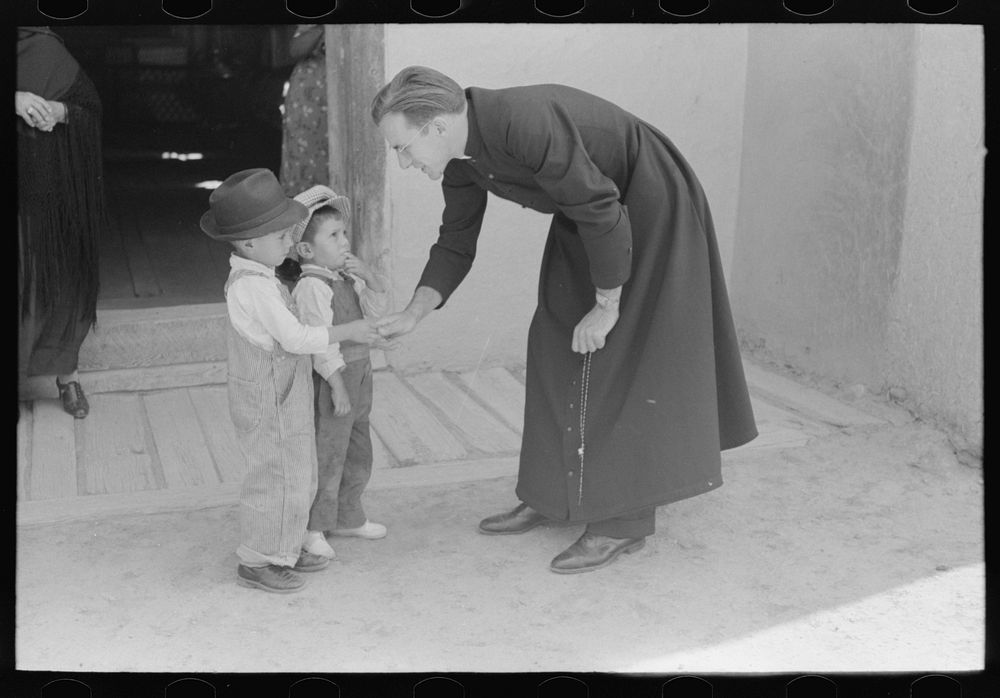 Catholic priest greeting small Spanish-American boy after Mass. Trampas, New Mexico by Russell Lee