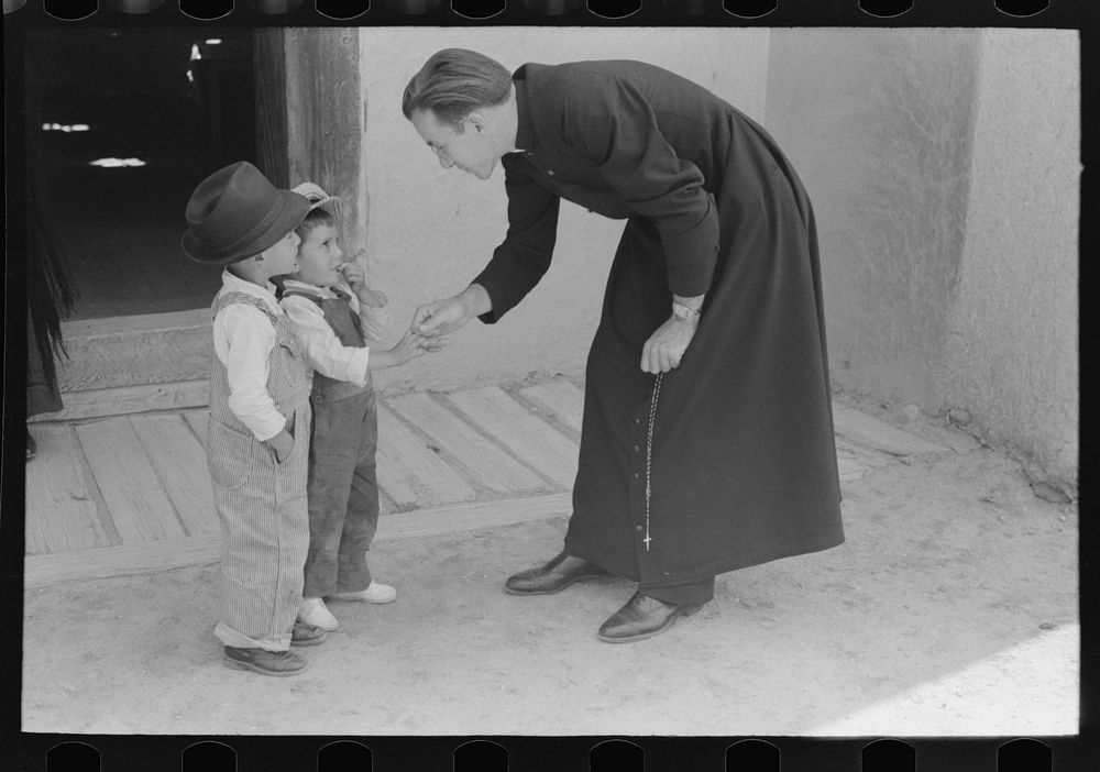 [Untitled photo, possibly related to: Catholic priest greeting small Spanish-American boy after Mass. Trampas, New Mexico]…