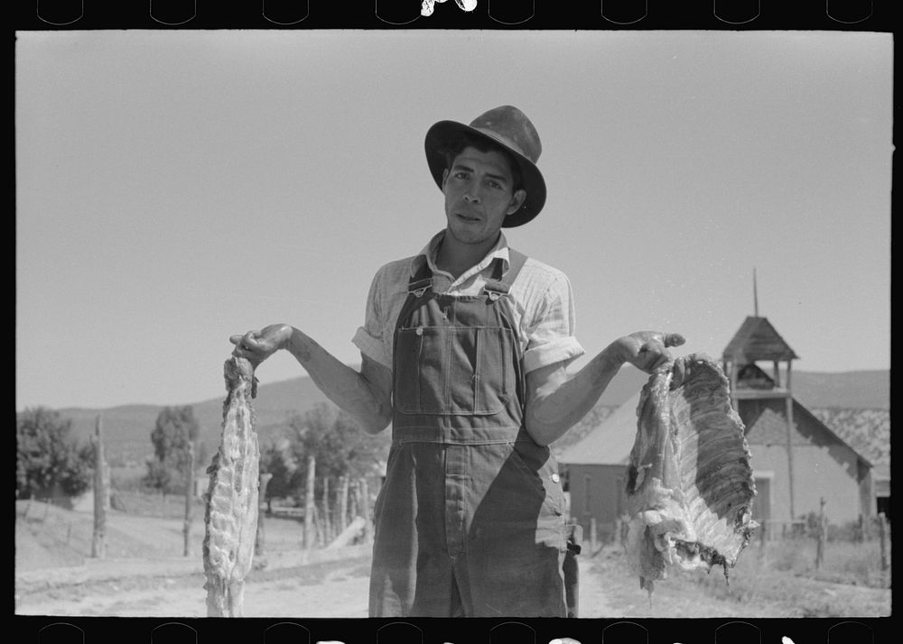 Spanish-American farmer with fresh pork. Chamisal, New Mexico by Russell Lee