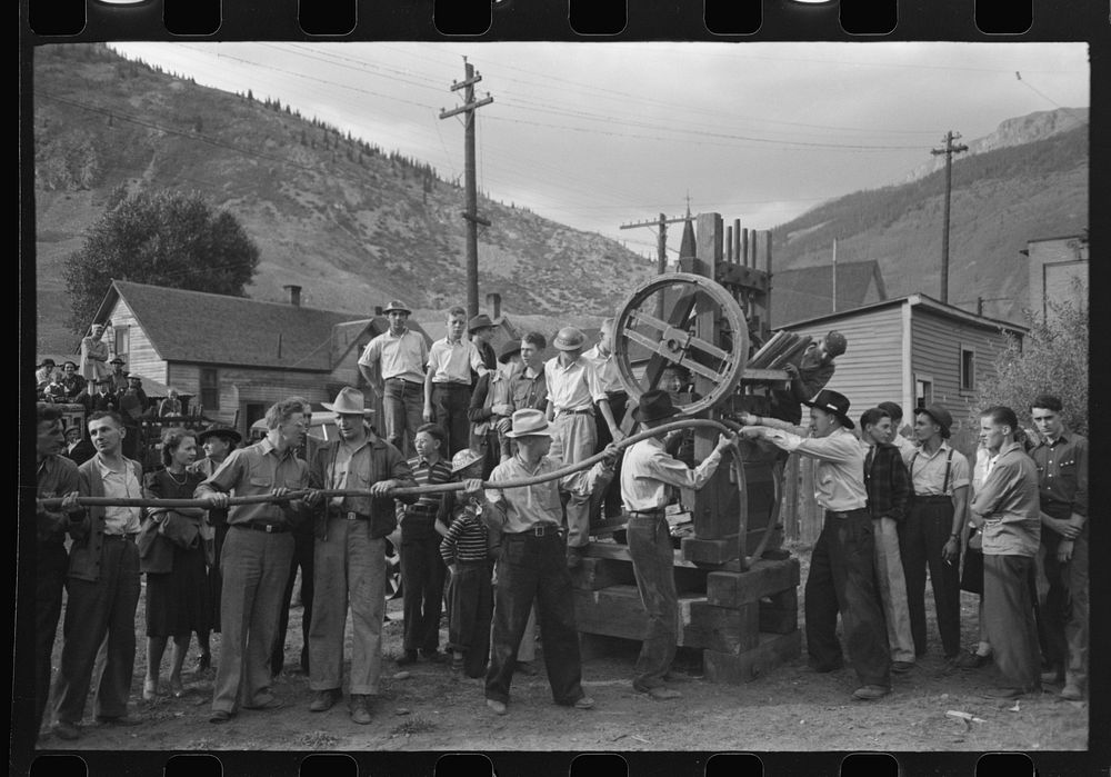 [Untitled photo, possibly related to: Miner attaching airhose to power drill which he will use in drilling contest, Labor…