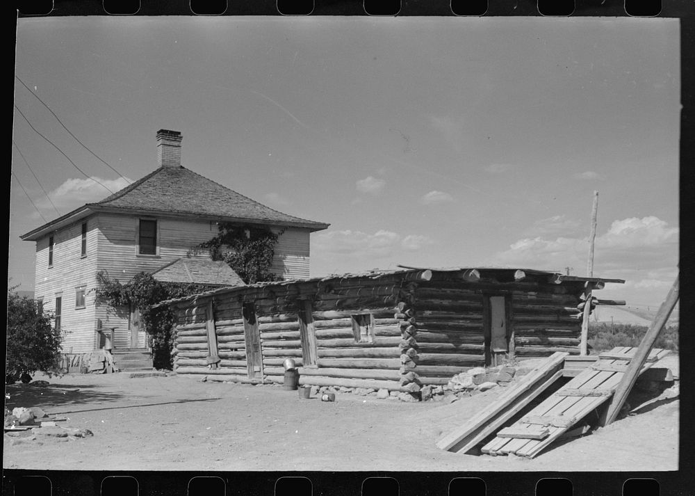 Delta County, Colorado. Home and old log cabin on a peach grower's farm. This man came from Oklahoma determined never again…