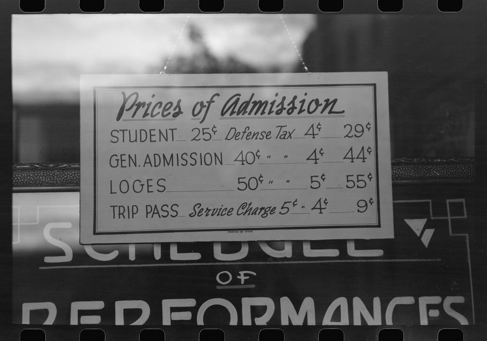 Price schedule in front of moving picture show. Redding, California by Russell Lee