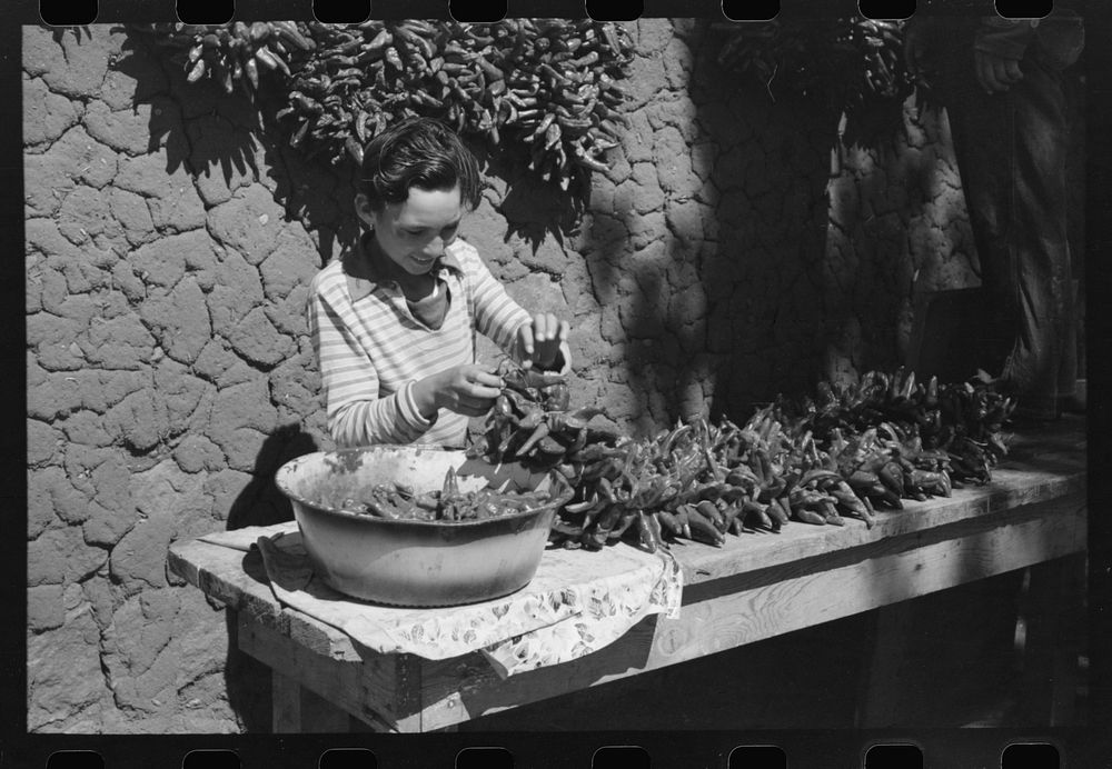 [Untitled photo, possibly related to: Spanish boy stringing chili peppers for drying, Concho, Arizona] by Russell Lee