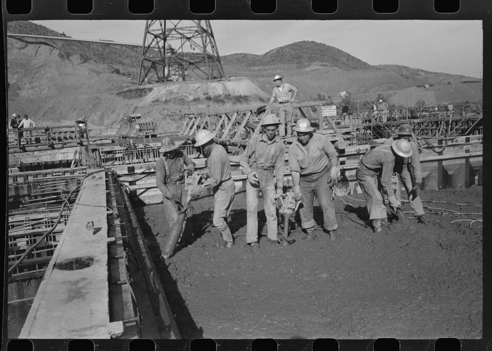 Construction workers using tools to settle freshly-poured concrete, Shasta Dam. Shasta County, California by Russell Lee