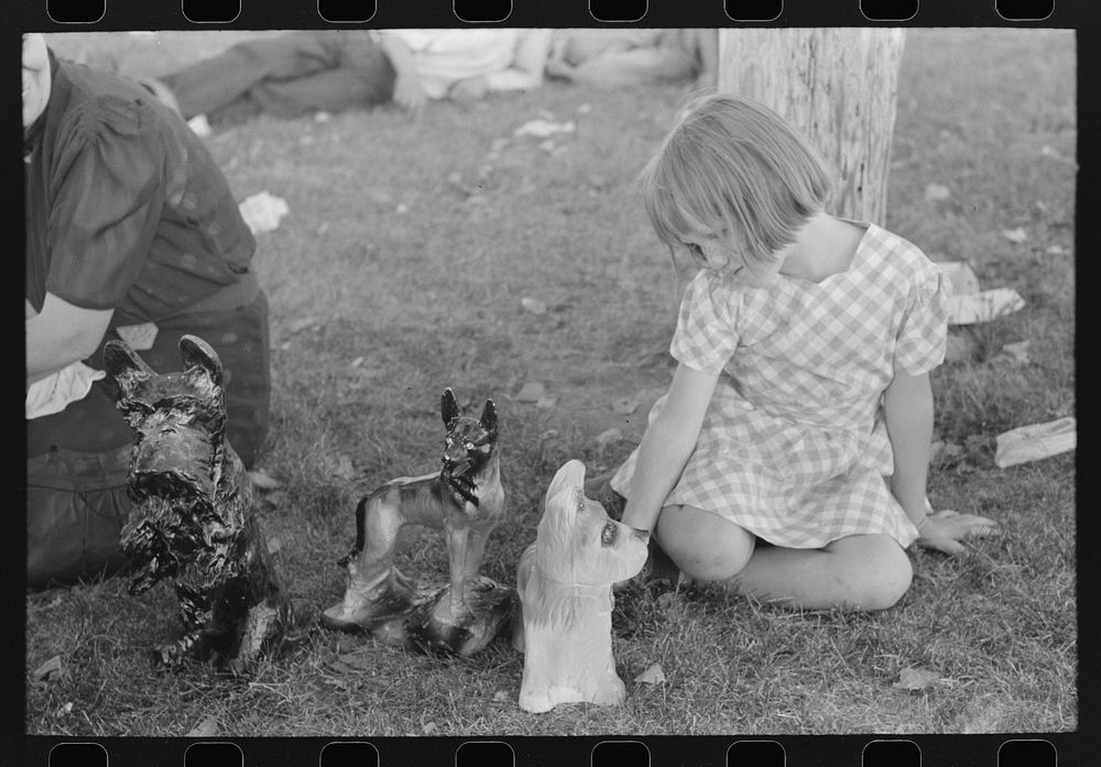 [Untitled photo, possibly related to: Little girl plays with prizes won at concession, Fourth of July, Vale, Oregon] by…