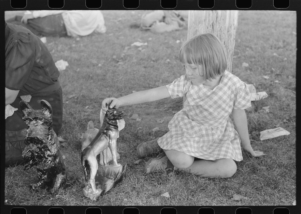 Little girl plays with prizes won at concession, Fourth of July, Vale, Oregon by Russell Lee