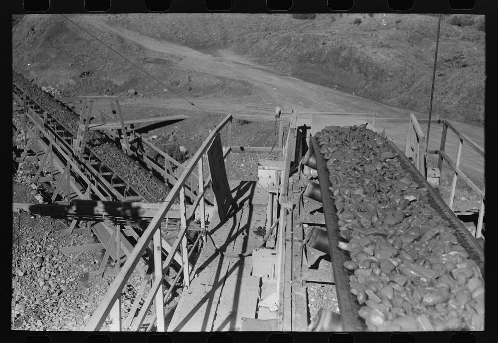 Gravel on long rubber conveyor belt at Shasta Dam, Shasta County, California by Russell Lee
