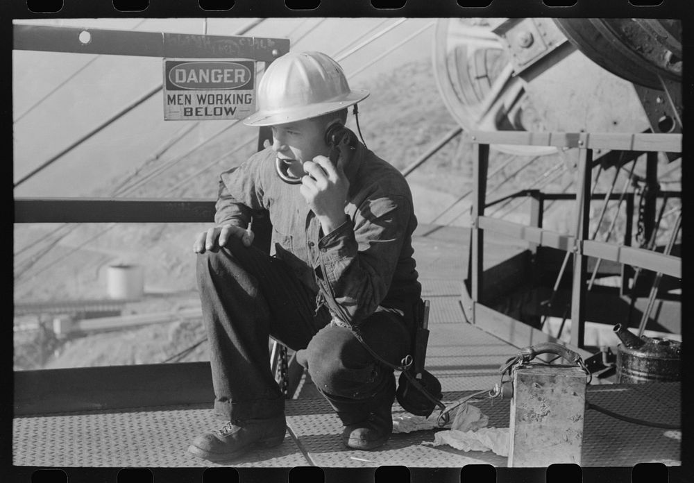 Workman keeps in touch with various construction points by telephone at Shasta Dam, Shasta County, California by Russell Lee