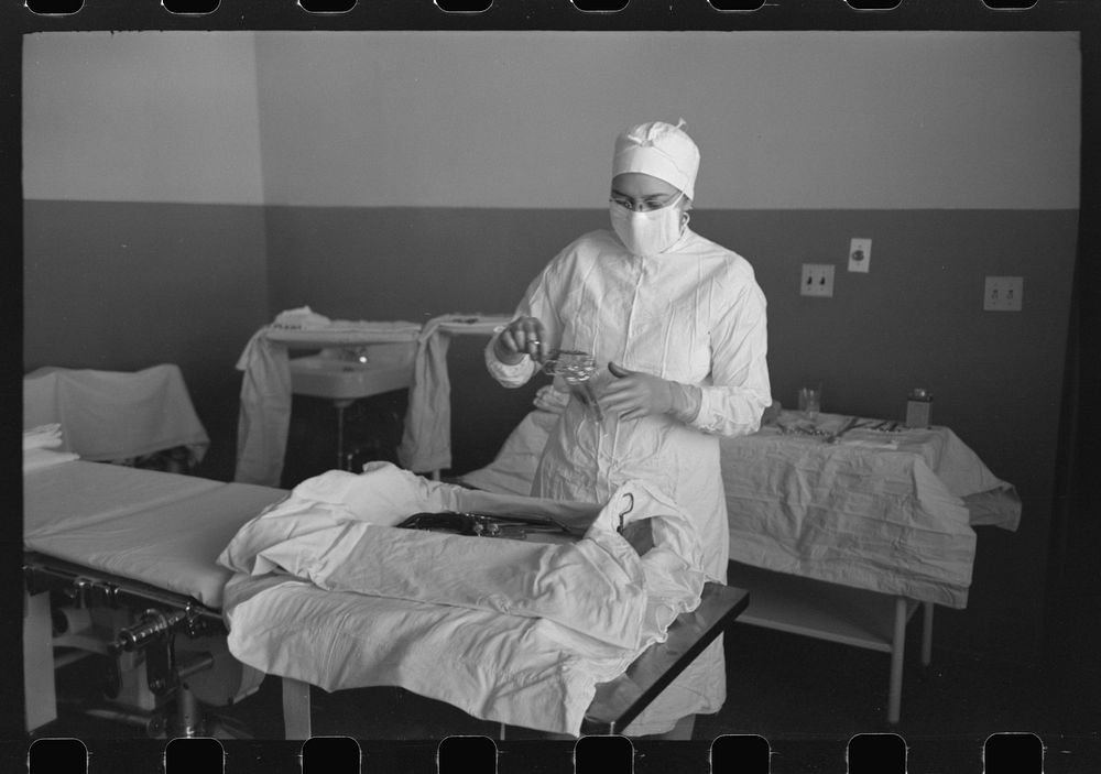 Sterile nurse lays out instruments for operation at the Cairns General Hospital at the FSA (Farm Security Administration)…