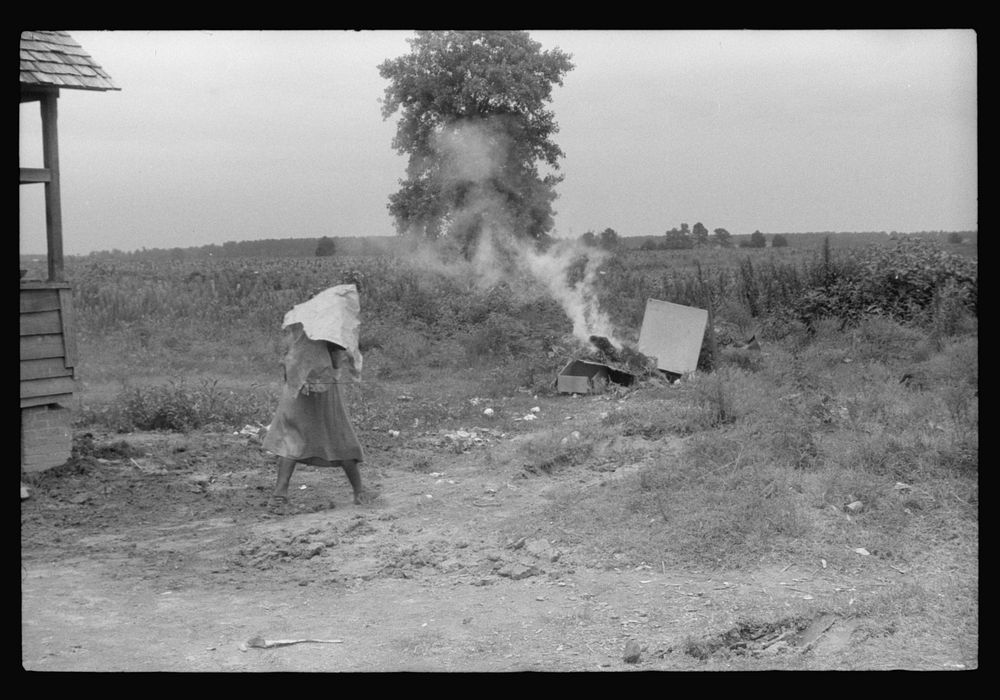 Migrant disposing of trash before leaving Belcross, North Carolina for another job at Onley, Virginia. Sourced from the…