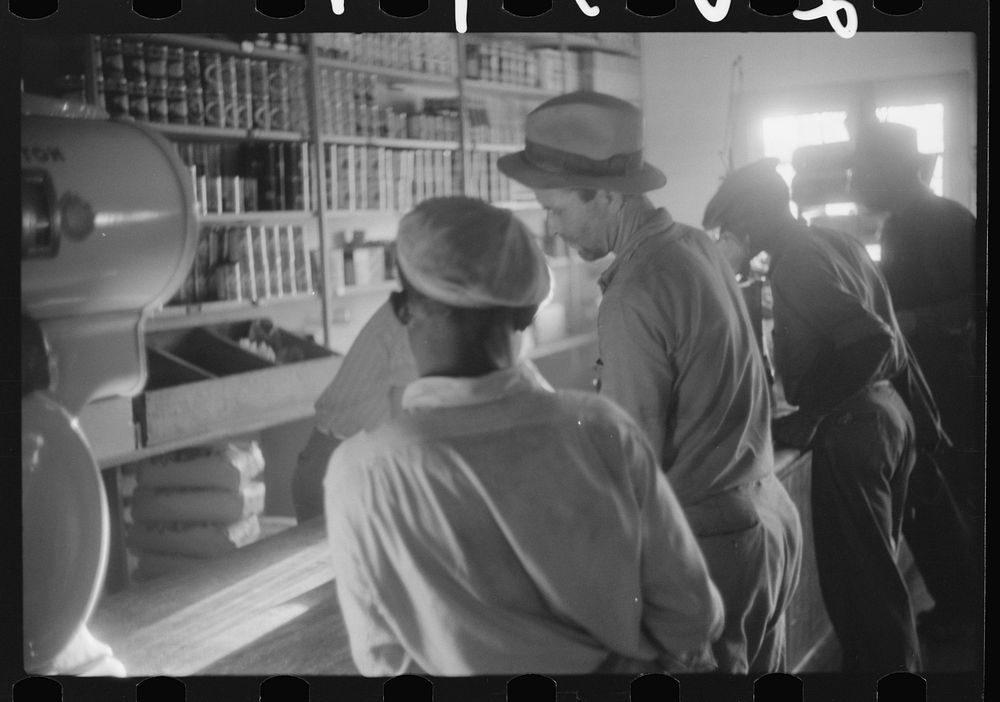 Migratory agricultural workers buying canned goods for supper at the company store. Belcross, North Carolina. Sourced from…