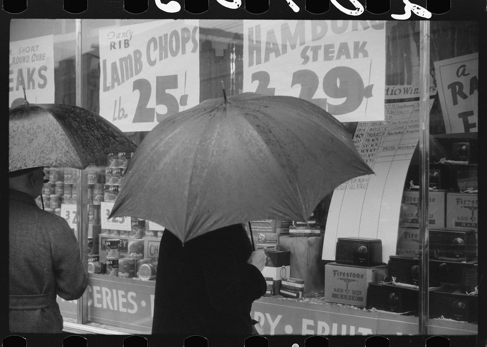 [Untitled photo, possibly related to: Woman window shopping on a rainy day in Norwich, Connecticut]. Sourced from the…
