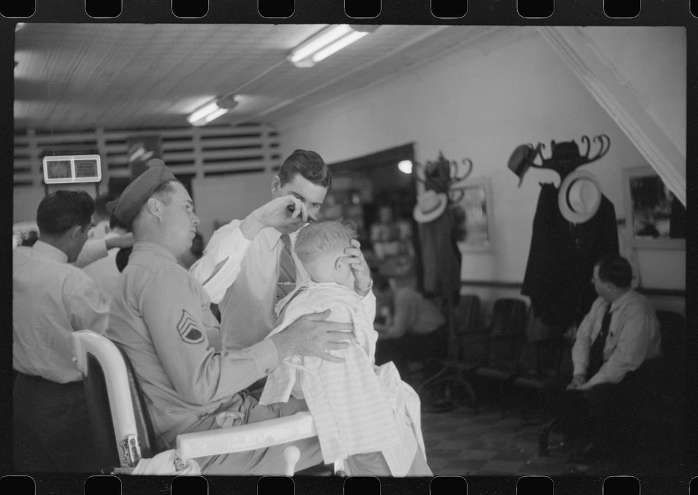 [Untitled photo, possibly related to: Sergeant from Fort Benning getting his son's hair cut at a barber shop in Columbus…