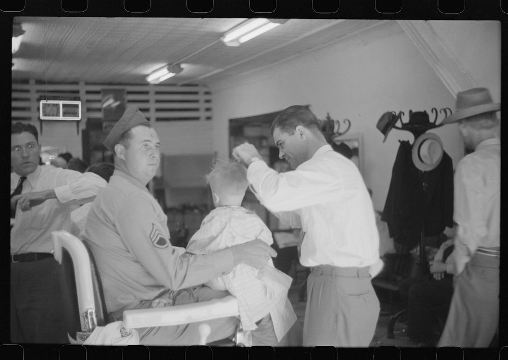 [Untitled photo, possibly related to: Sergeant from Fort Benning getting his son's hair cut at a barber shop in Columbus…