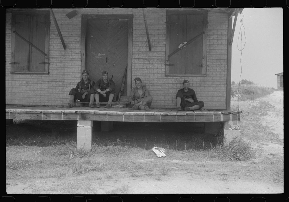 Soldiers resting at an abandoned store during maneuvers in Caroline County, Virginia. Sourced from the Library of Congress.
