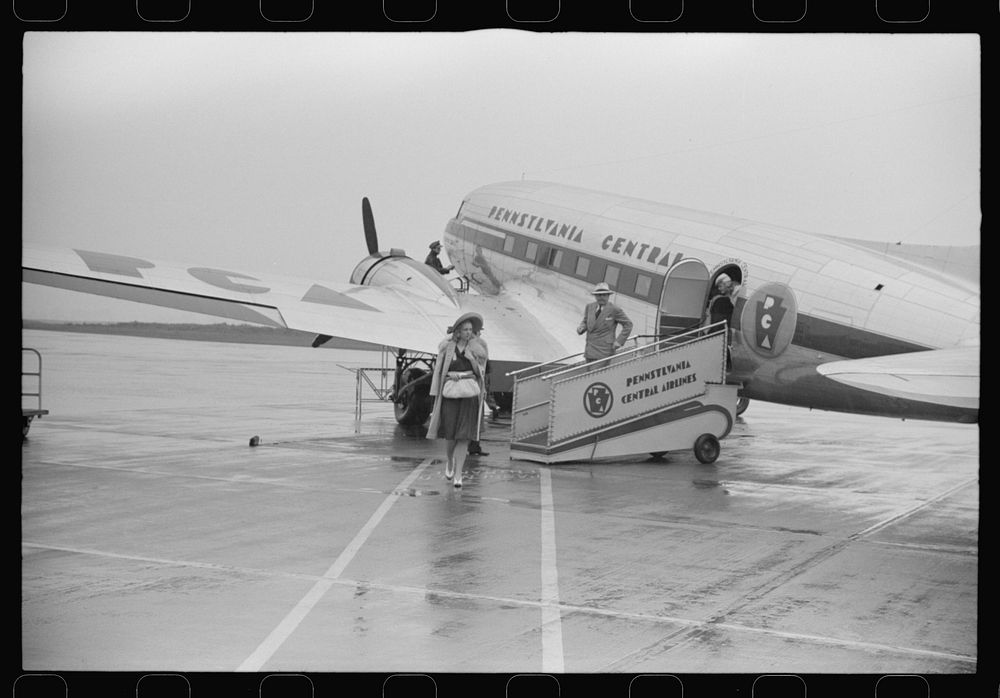 Passengers boarding a plane on a rainy day at the municipal airport in Washington, D.C.. Sourced from the Library of…