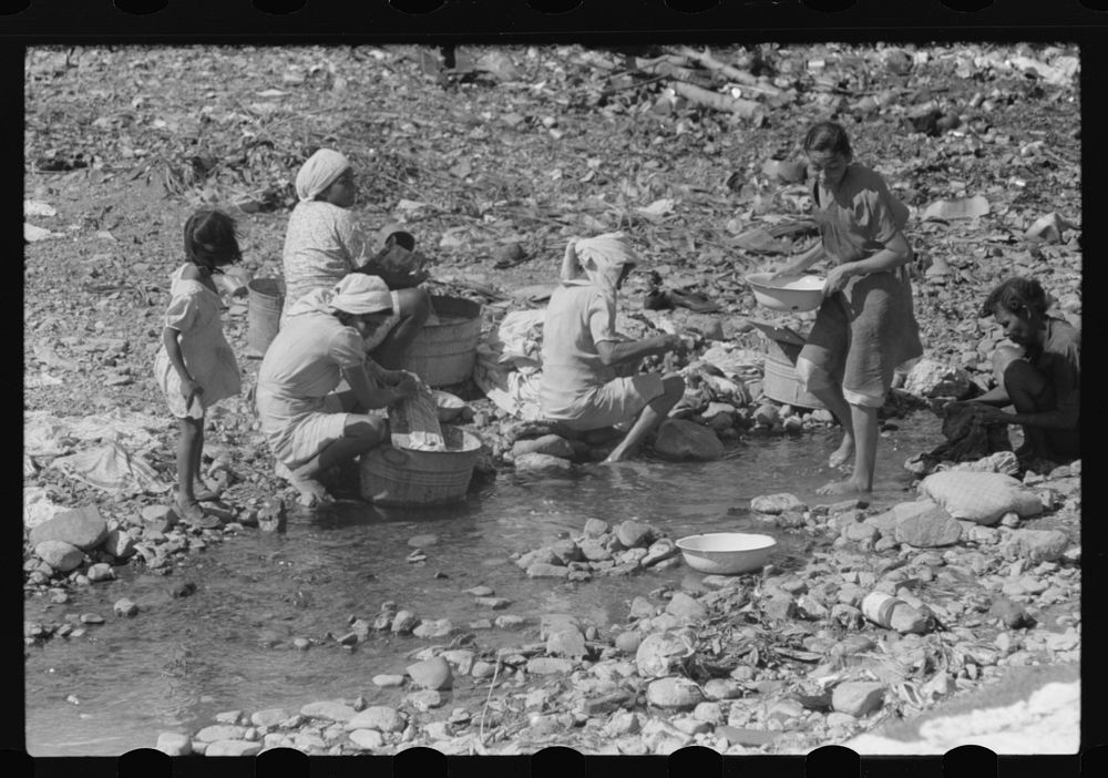 Washing clothes in the river near the slum area known as "El Machuelitto" in Ponce, Puerto Rico. Sourced from the Library of…