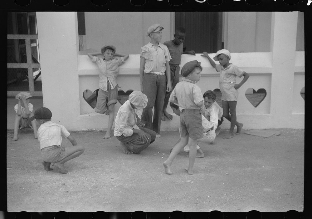 French Village, a small settlement on St. Thomas Island, Virgin Islands. Boys playing marbles outside of a general store.…