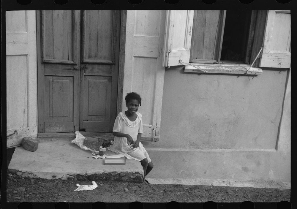 [Untitled photo, possibly related to: Little girl playing with her Christmas presents on a side street in Charlotte Amalie…