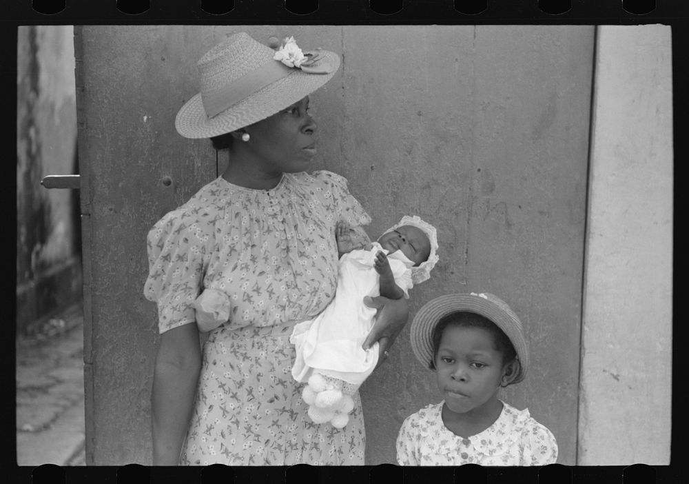 Charlotte Amalie, St. Thomas Island, Virgin Islands. Mother and children waiting on the main street on Sunday. Sourced from…