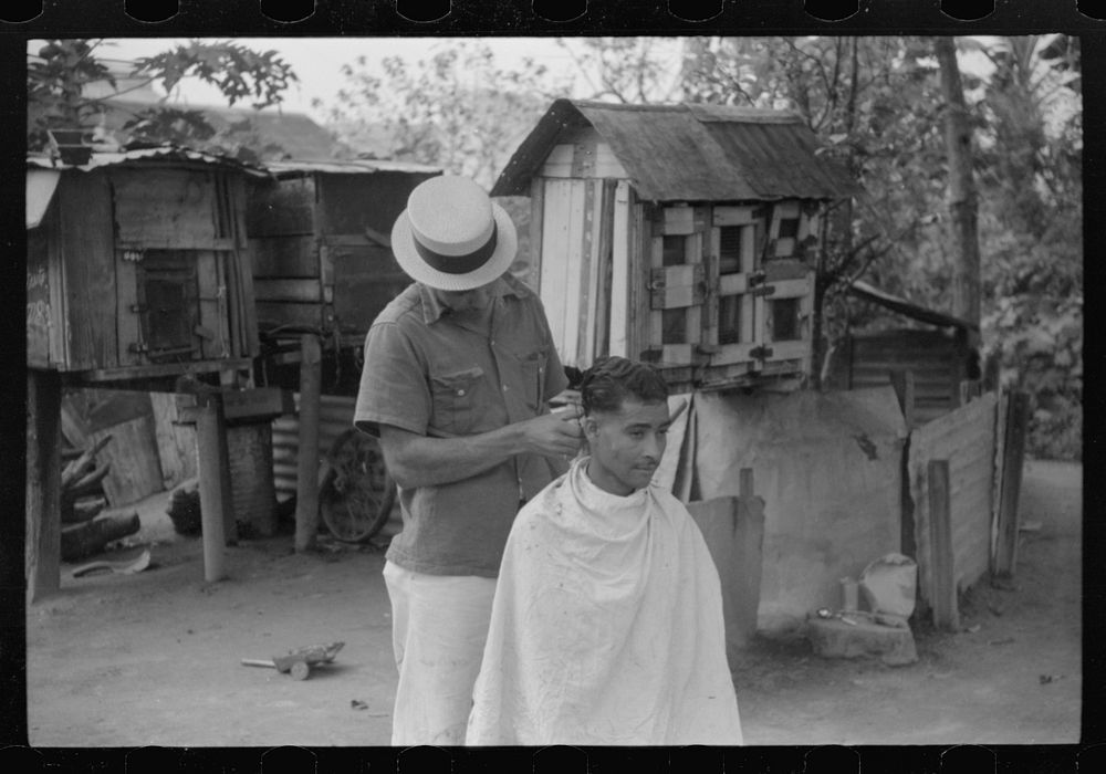 [Untitled photo, possibly related to: Yabucoa, Puerto Rico. Striker getting a haircut in the mill village near the sugar…