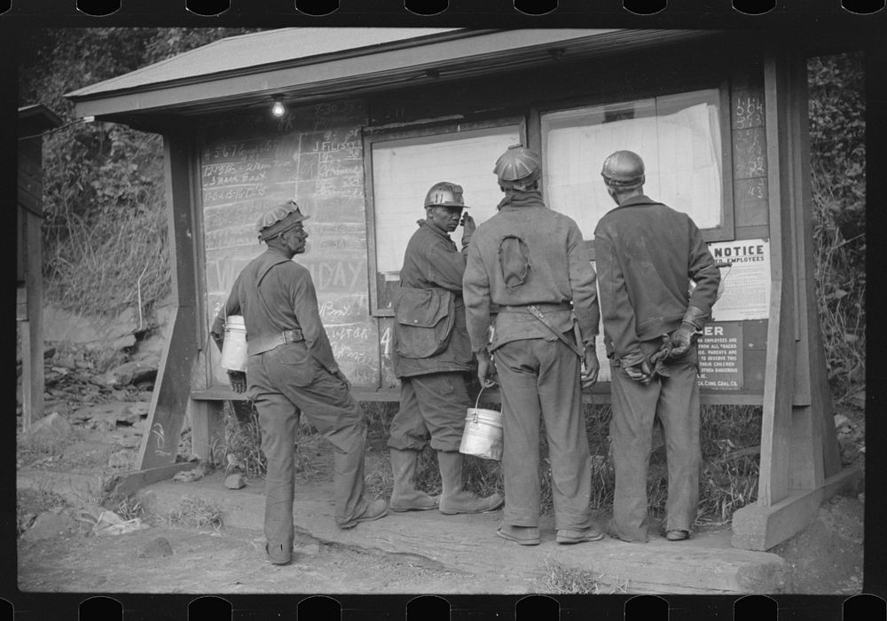 [Untitled photo, possibly related to: Miners looking at daily reports, checking the number of tons of slate and coal they…