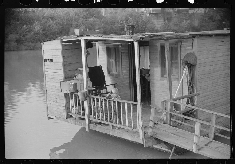 Child on back porch of his home, riverboat house in Charleston, West Virginia. Sourced from the Library of Congress.