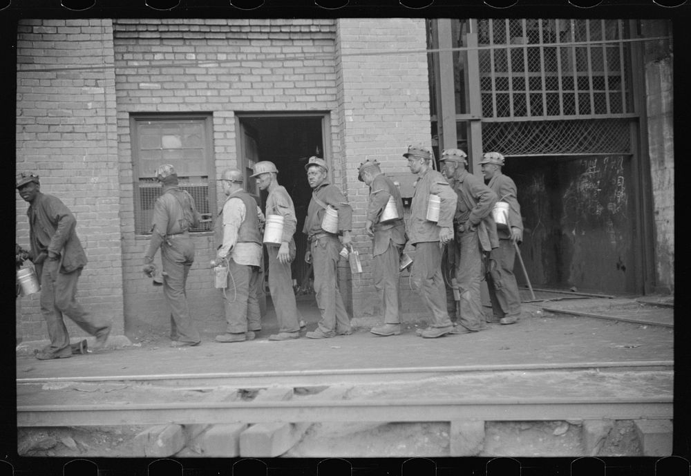 [Untitled photo, possibly related to: Miners turning in lamps after getting out of cage from shaft, which goes down sixty…