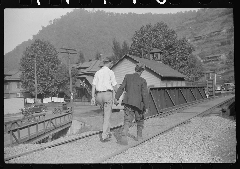 Coal miner going home with friend after work. Many miners are lame. Omar, West Virginia. Sourced from the Library of…