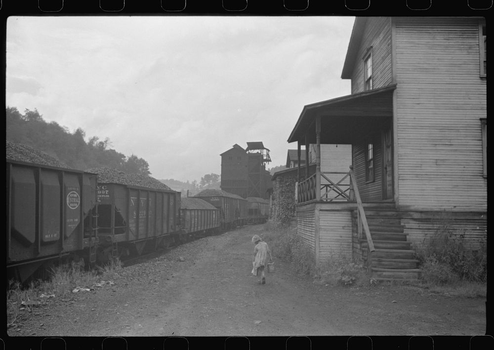 Coal miner's child taking home kerosene for lamps. Company houses, coal tipple in background. Pursglove, Scotts Run, West…