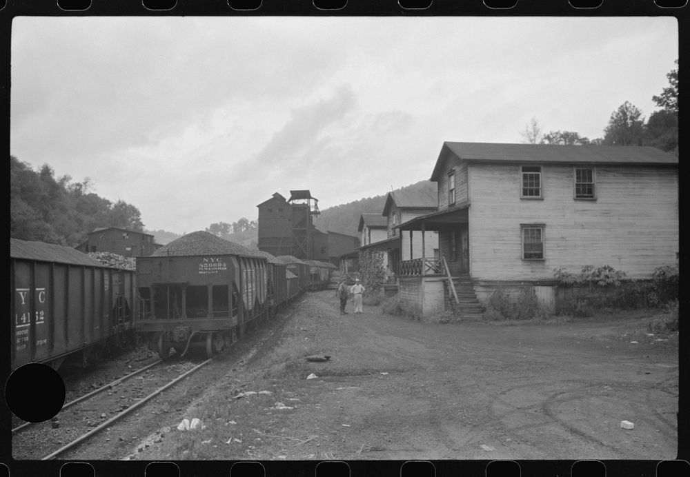 [Untitled photo, possibly related to: Coal miner's child taking home kerosene for lamps. Company houses, coal tipple in…